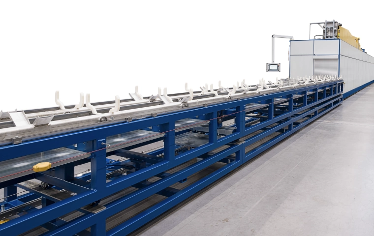 Industrial solvent-based degreasing machine with a conveyor belt for tubular parts.
