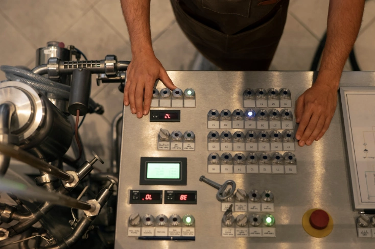 Operador que utiliza un panel de control para manejar un proceso de limpieza industrial.